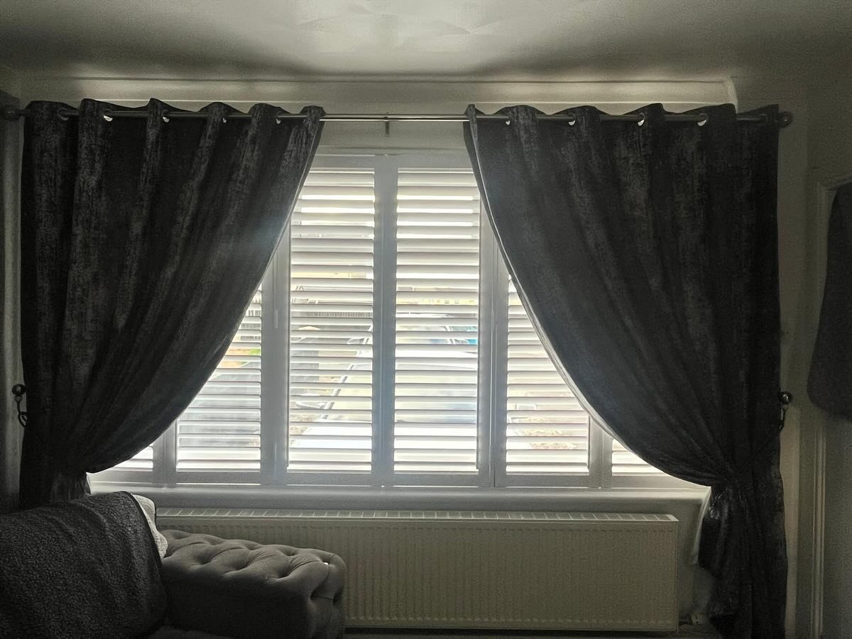 White shutters fitted behind curtains in a Glasgow living room